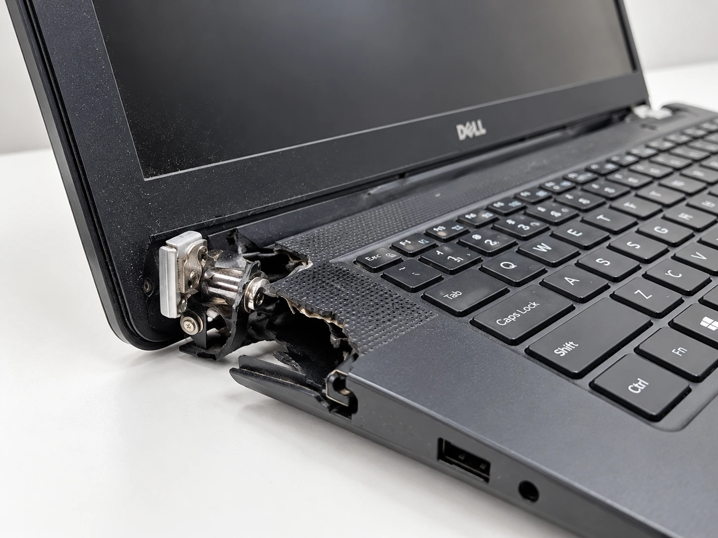 Notebook Dell con carcasa quebrada y bisagra expuesta en la zona de apertura